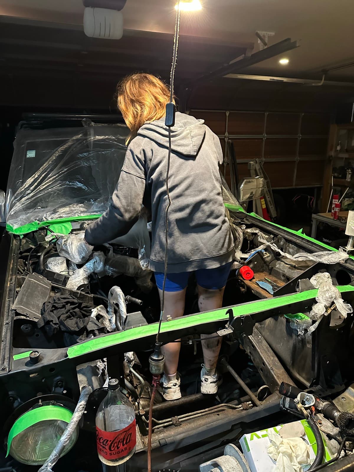 A member of the Hoist team working in the engine bay of a Nissan Patrol during an engine swap